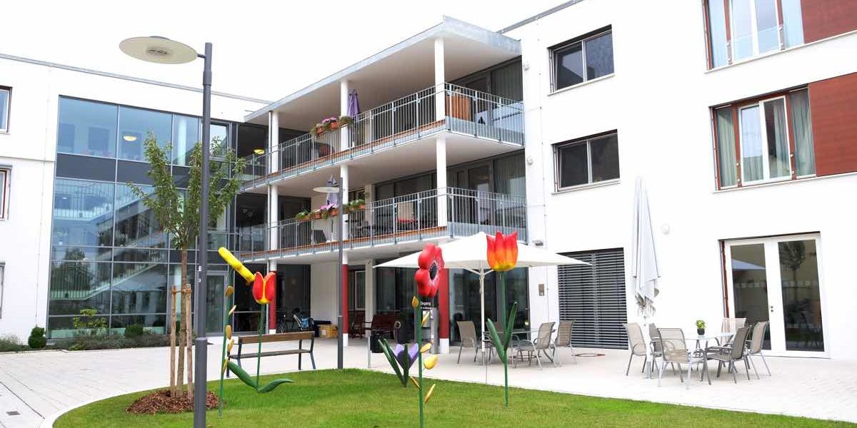 Moderne Wohnanlage mit Balkonen, Spielplatz und gepflegtem Garten, ideal für Familien und aktive Lebensstile.